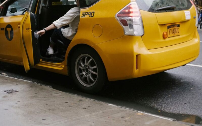 Pasajero cerrando la puerta de un taxi, ilustrando un viaje seguro que genera cashback